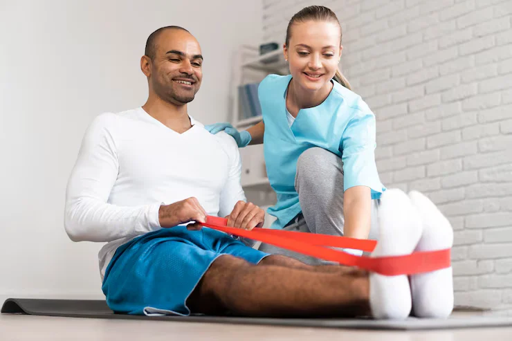Man and female physiotherapist performing resistance band exercises during sports rehabilitation session in Tampa.
